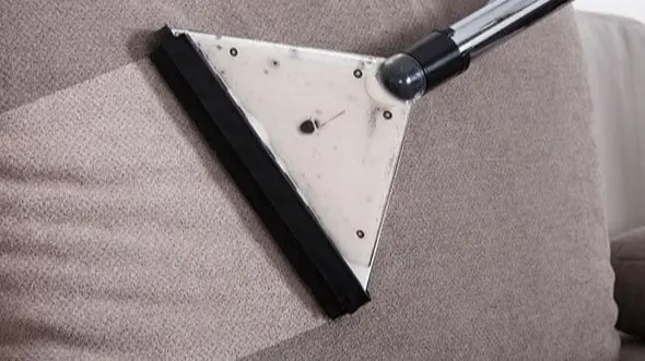 Sofareinigung München Frau sitzt glücklich auf einem frisch gereinigten Sofa