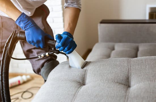 Detailansicht der professionellen Dampfreinigung eines hellen Sofas in einer Münchner Wohnung mit sichtbarem Dampfaustritt